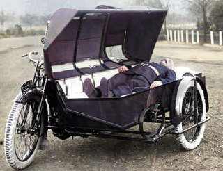 圣约翰会早期救护车。病人被安置在类似棺材的侧车中，通过舱口呼吸——运输时盖子会关闭，约1922年